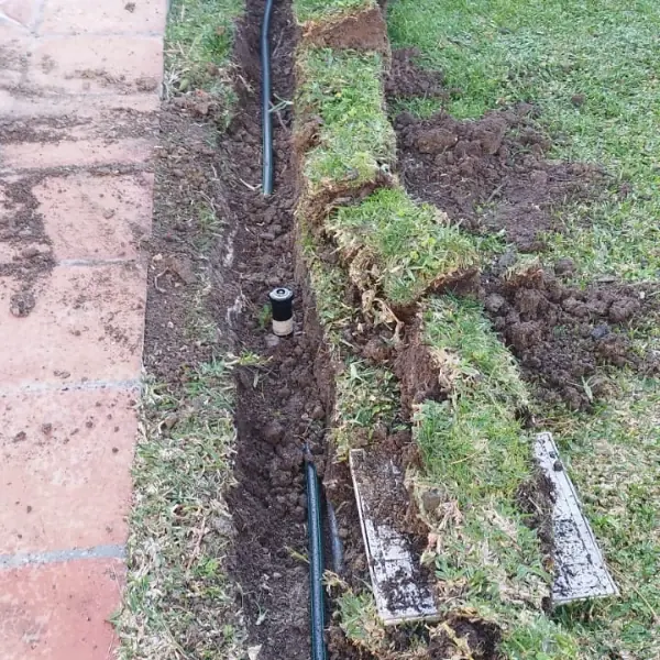 instalando un sistema de riego, se ve la zanja abierta y el proceso